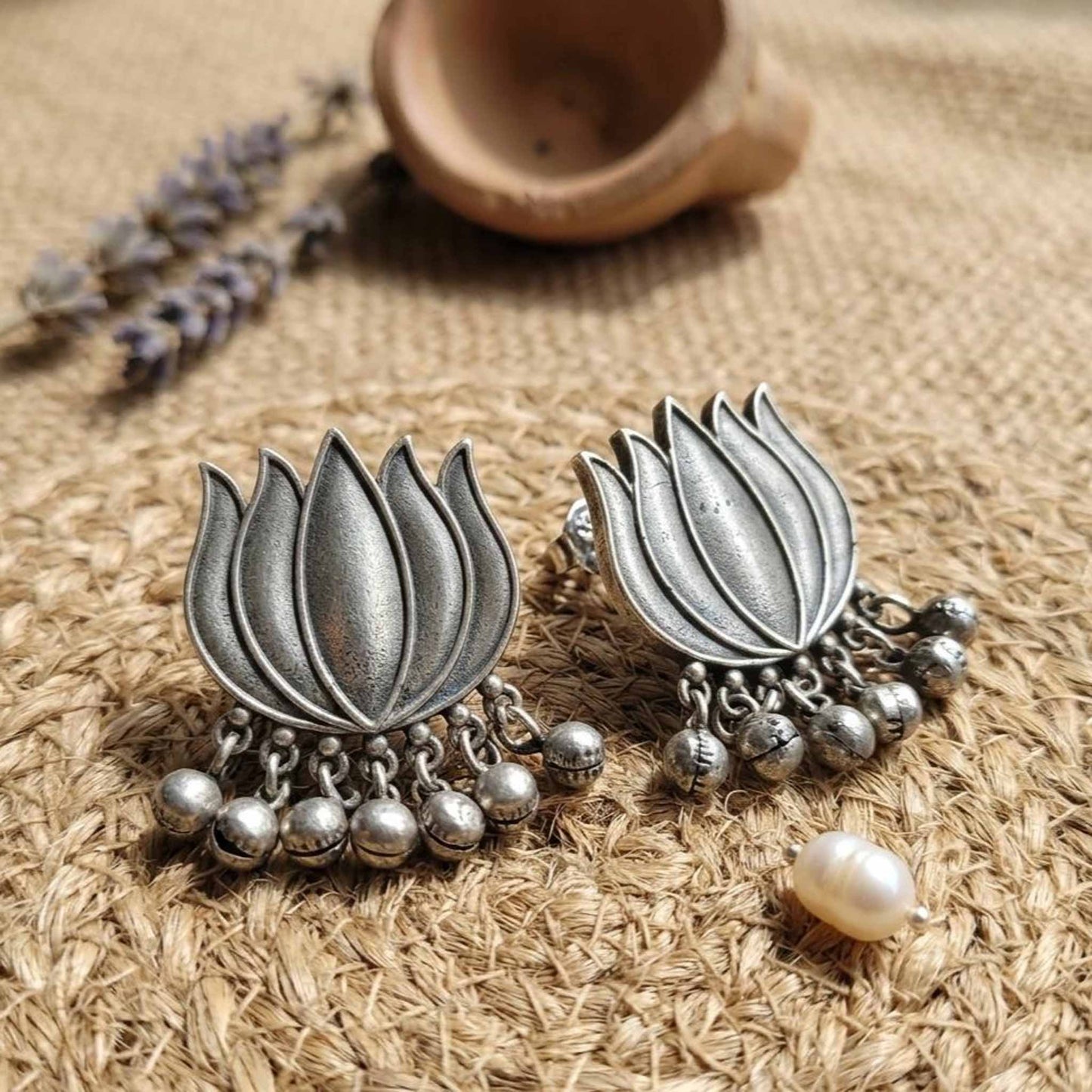 Close-up oxidised lotus ghunghru earrings with dangling beads
