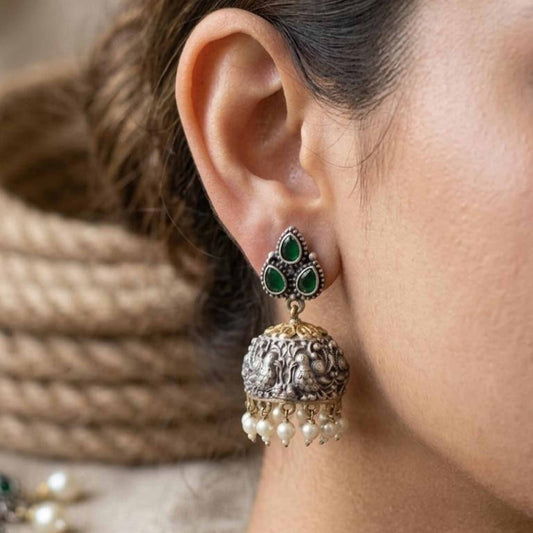 Model wearing emerald peacock embossed jhumka earrings