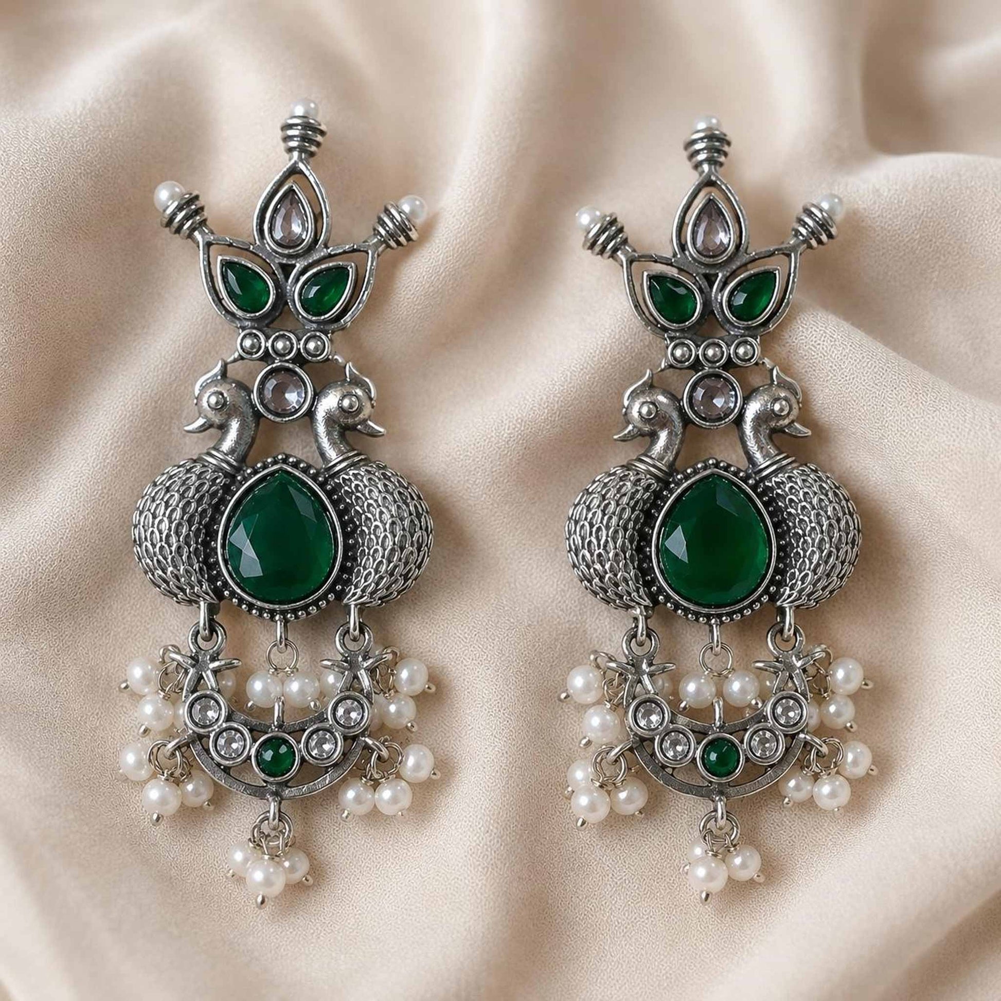 Traditional emerald peacock earrings flatlay