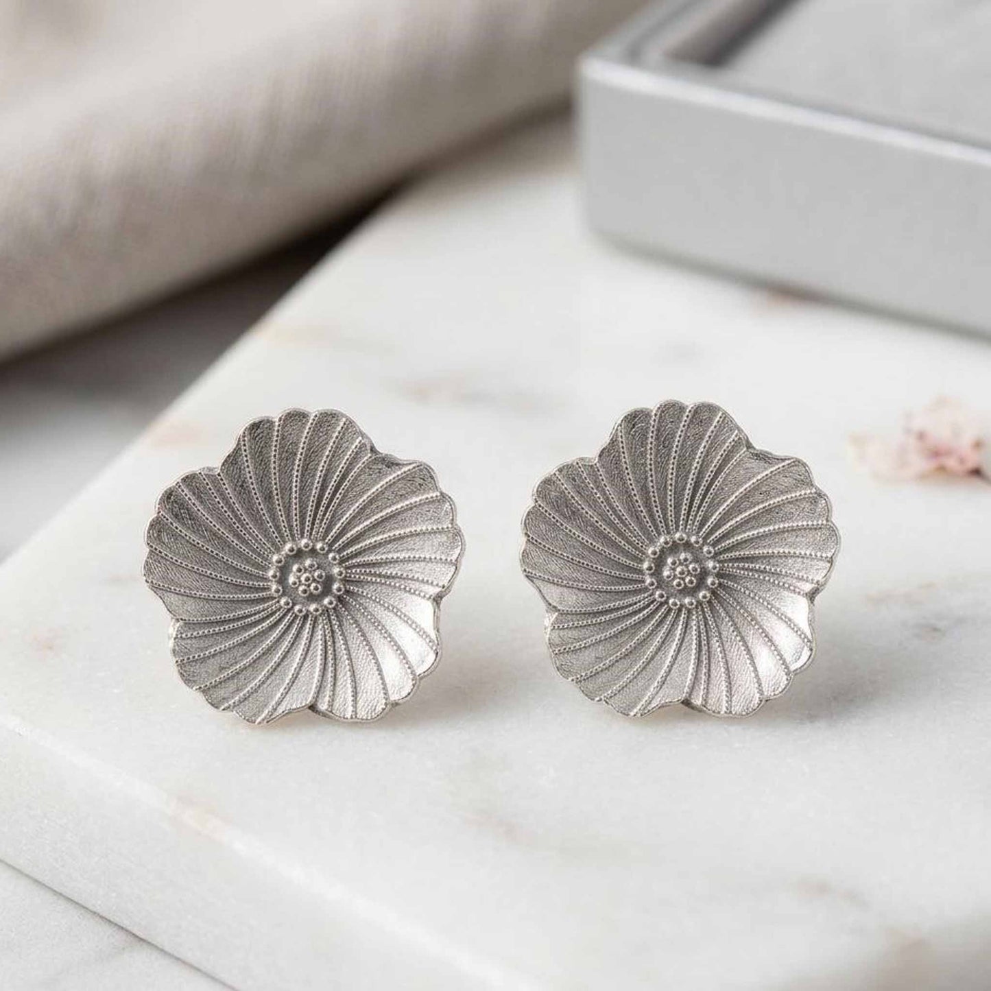 Silver flower stud earrings close-up display