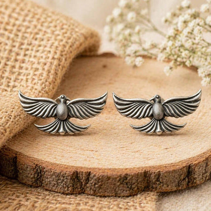 German silver bird earrings displayed on wooden base