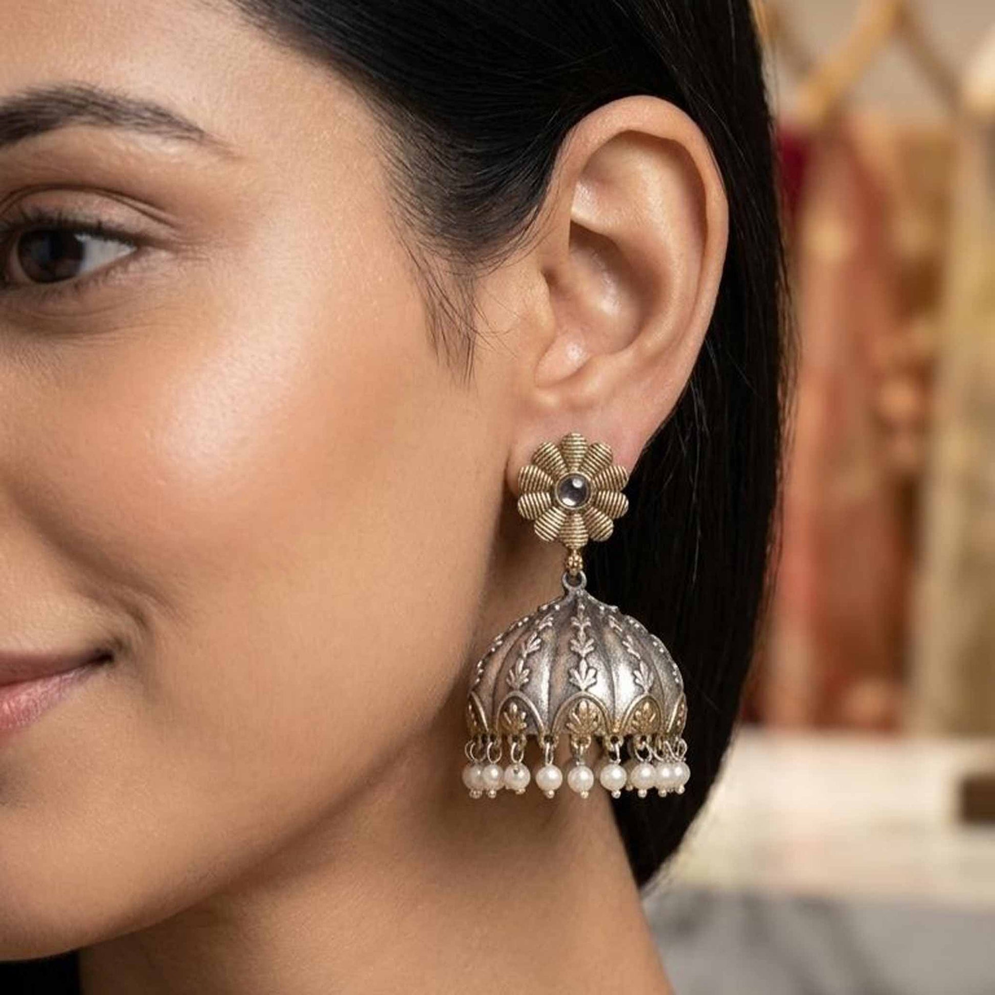 Model wearing dual tone pearl jhumka earrings