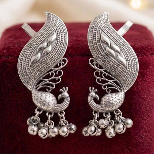 Peacock ear cuff earrings on velvet background