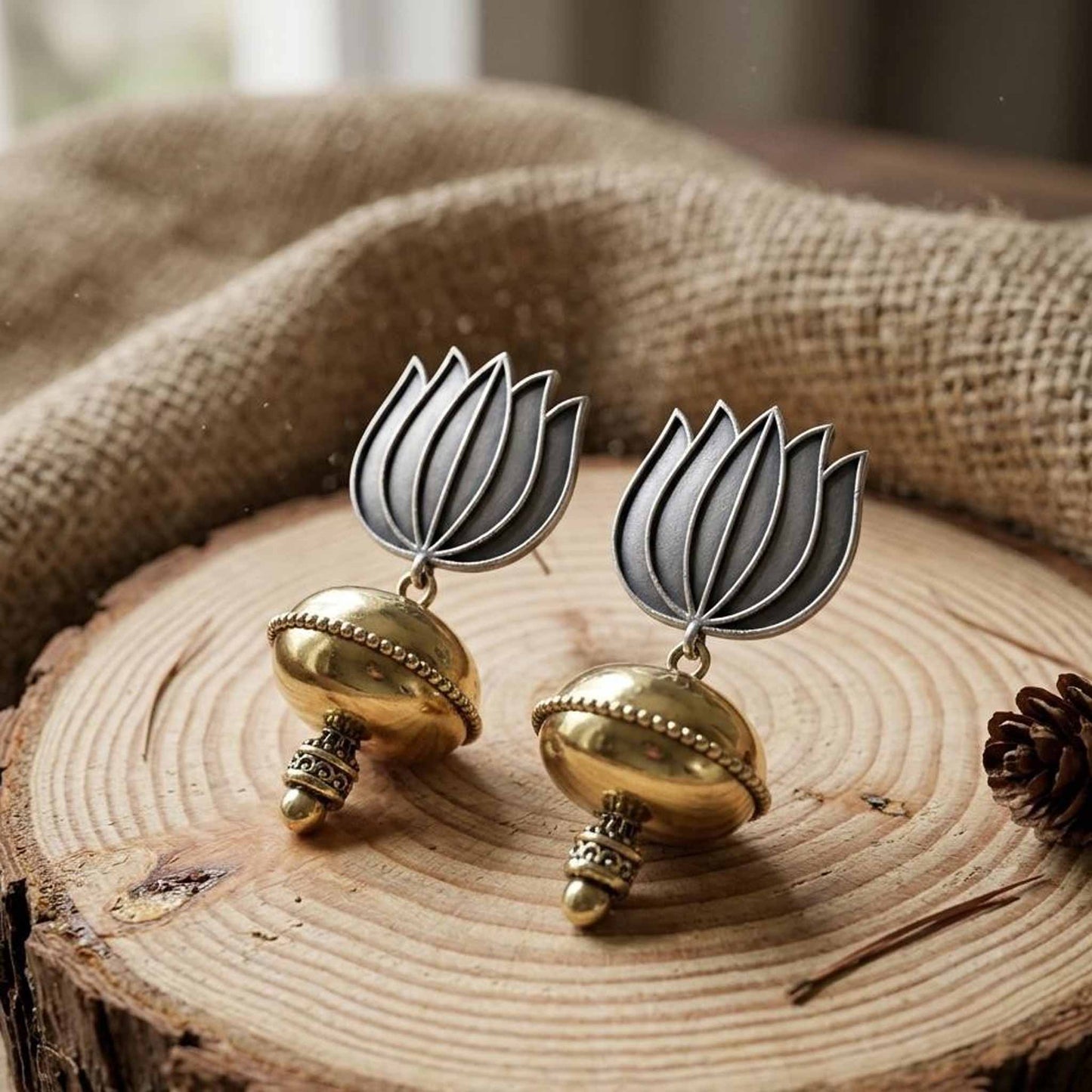 Handcrafted lotus dome jhumka earrings on wooden surface