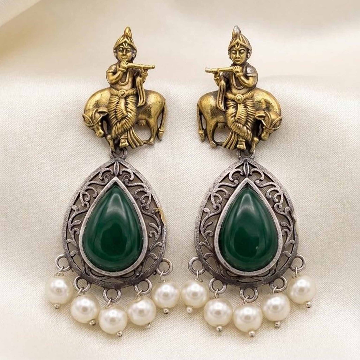 Flatlay image of handcrafted Krishna earrings with emerald stones
