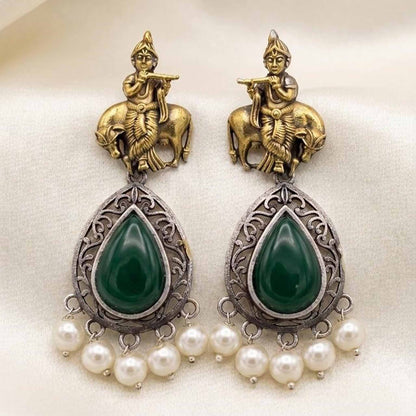 Flatlay image of handcrafted Krishna earrings with emerald stones