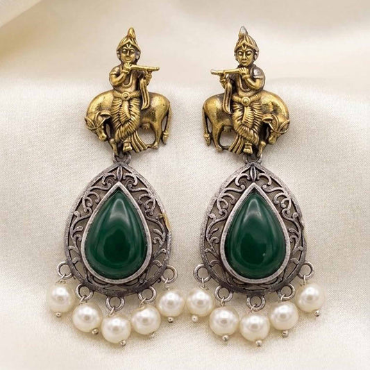Flatlay image of handcrafted Krishna earrings with emerald stones