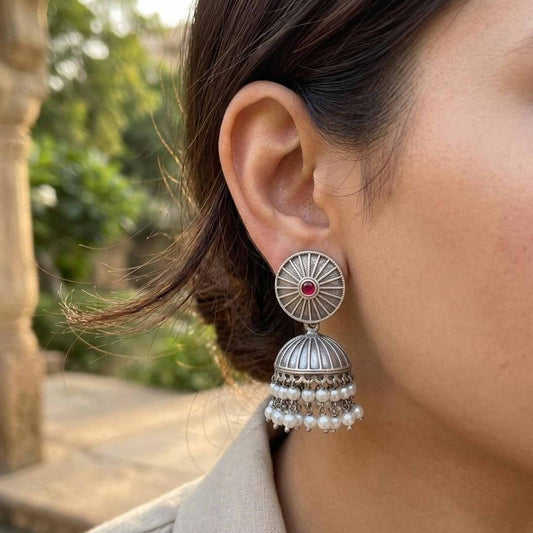 Woman wearing ruby pearl jhumka earrings