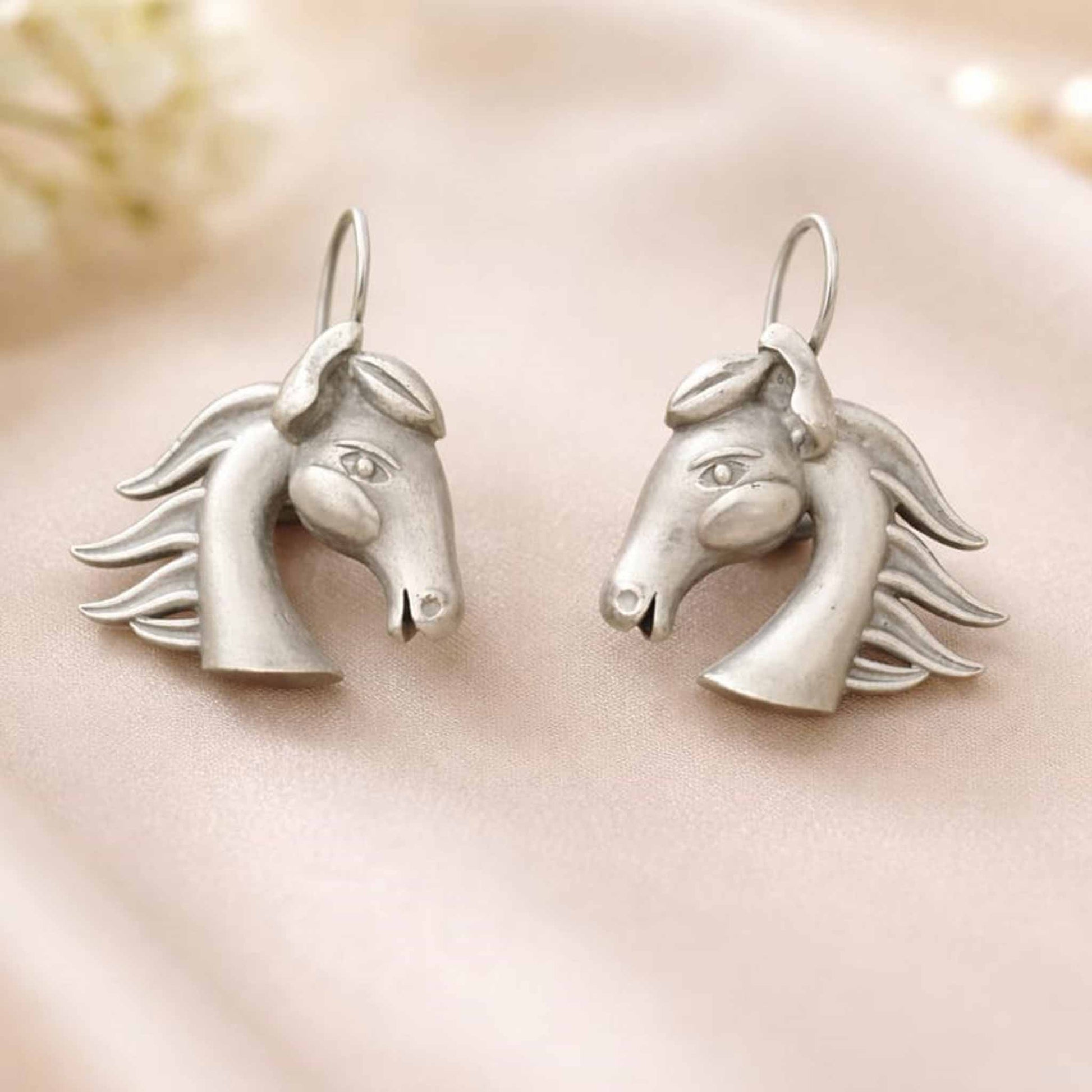 Horse head German silver earrings product display on soft fabric