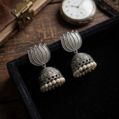 Lotus pearl jhumka earrings displayed on velvet tray