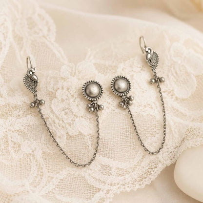 Peacock chain earrings displayed on white lace cloth
