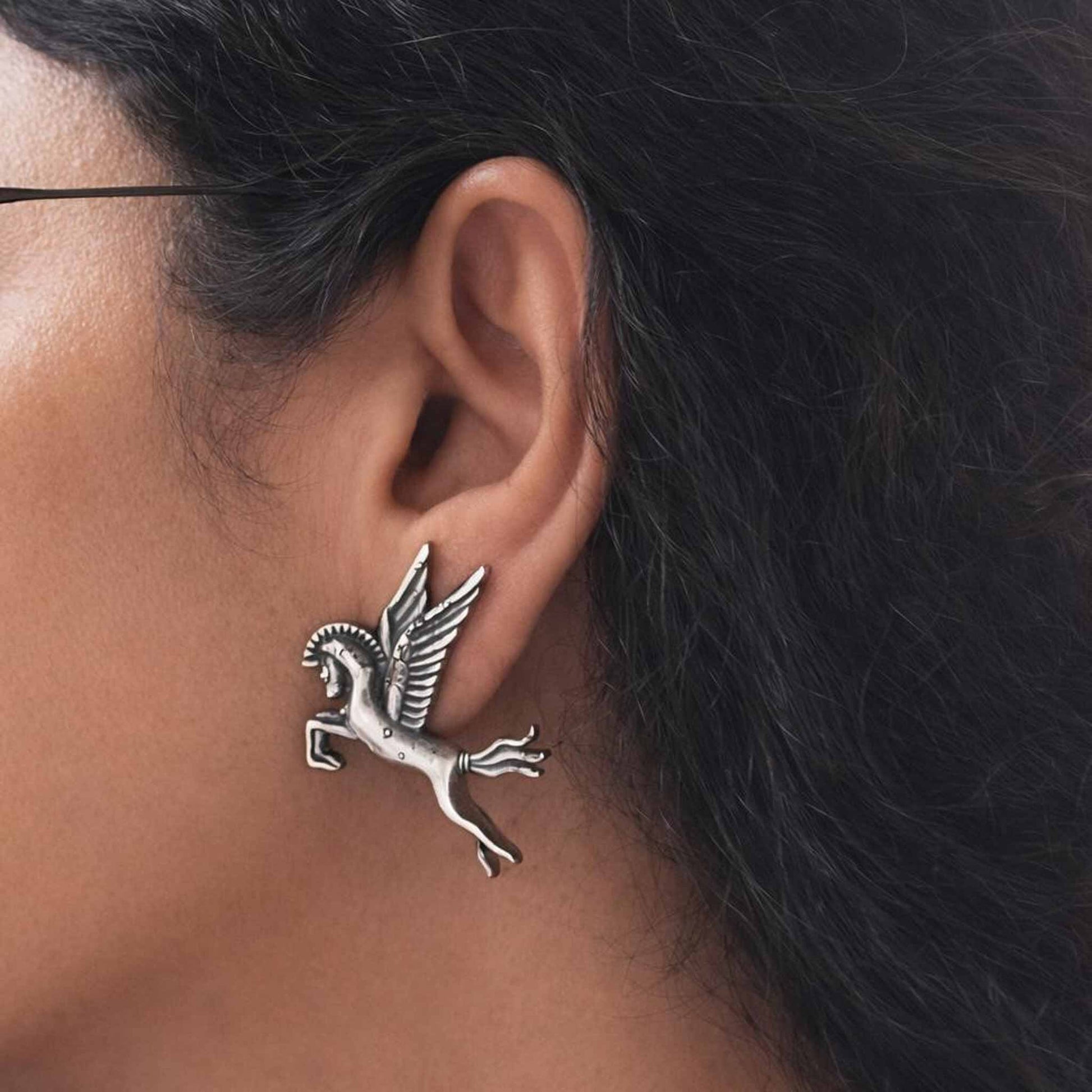 Closeup ear styling view of Pegasus German silver earrings