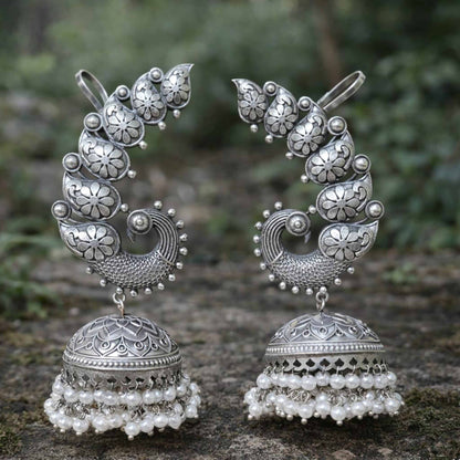 Outdoor closeup of peacock earcuff jhumka earrings with pearl beads