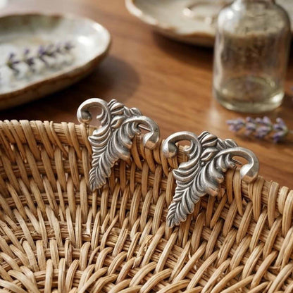 Leaf stud earrings displayed on woven basket