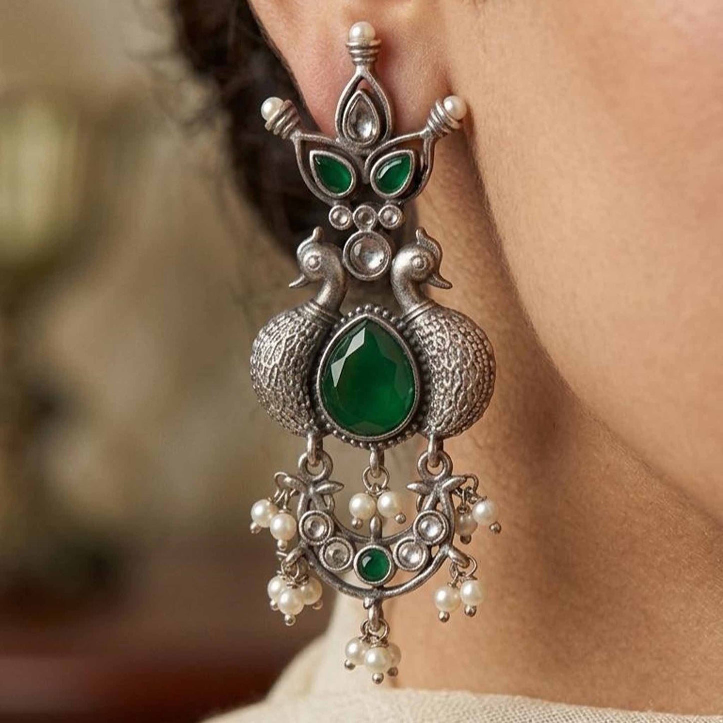 Closeup of emerald peacock German silver earrings