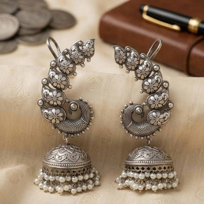 Closeup of antique silver peacock earcuff jhumka earrings