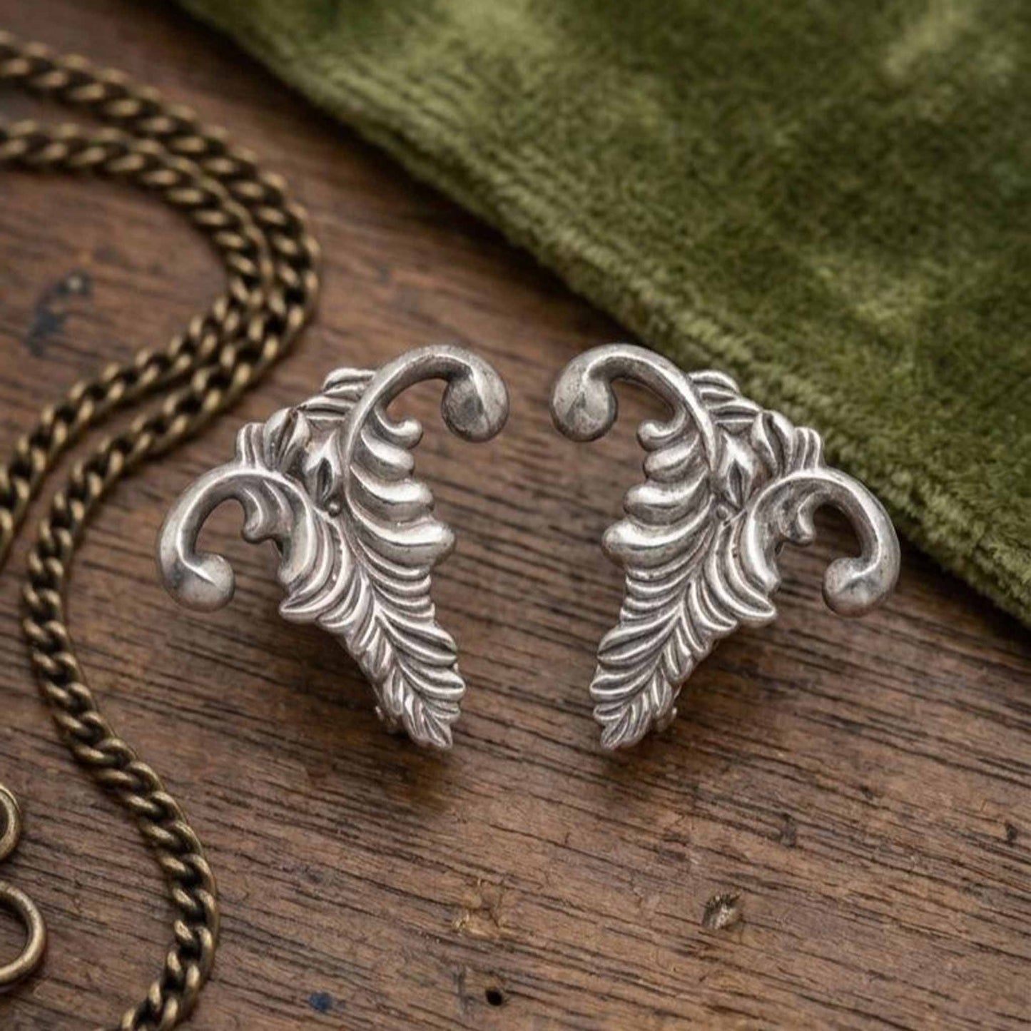Vintage leaf earrings flatlay on wooden surface