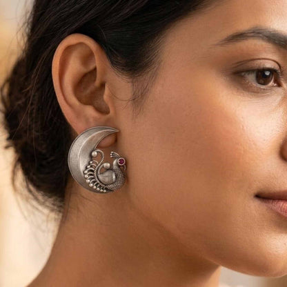 Model wearing peacock moon statement stud earrings