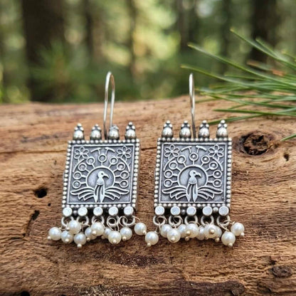 Peacock embossed German silver earrings with pearl danglings