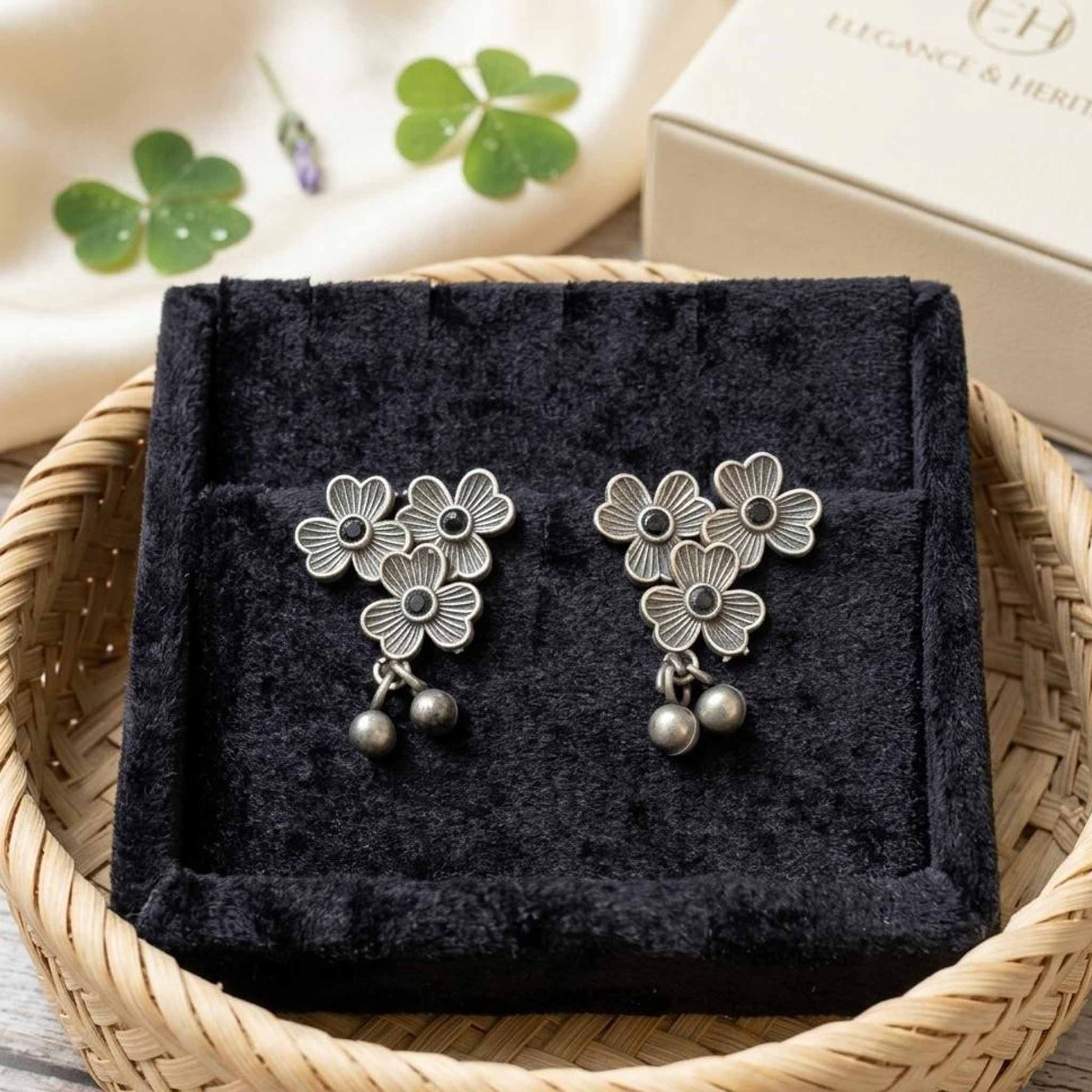 Three flower German silver earrings displayed in jewellery tray