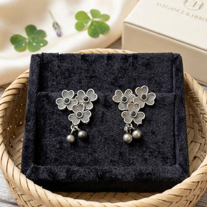 Three flower German silver earrings displayed in jewellery tray