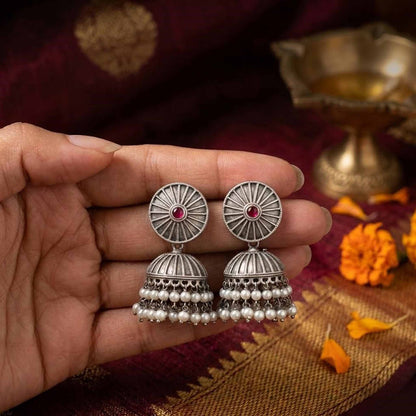 Hand holding German Silver silver pearl jhumkas