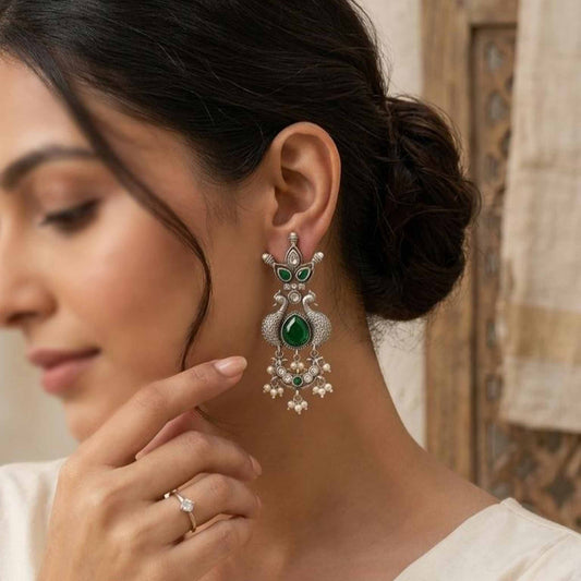 Woman wearing emerald peacock pearl German silver earrings