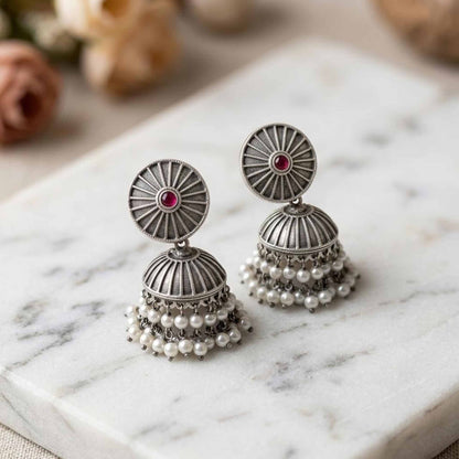 Pearl jhumka earrings flatlay on marble