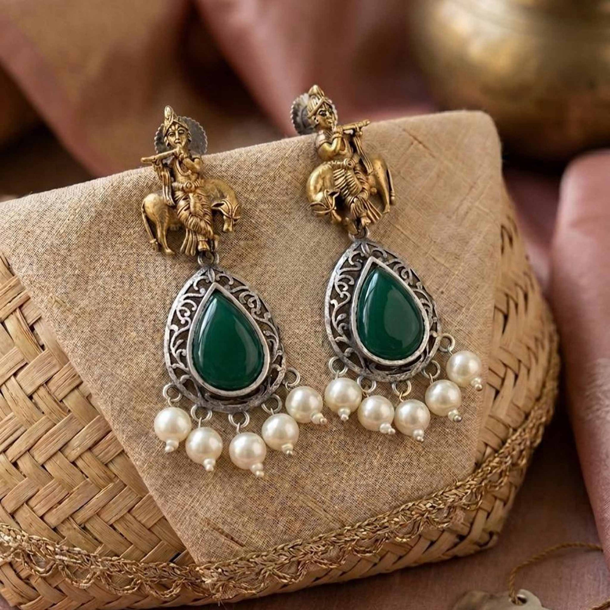 Styled ethnic display of Krishna emerald earrings