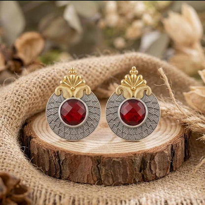 Ruby dual tone statement earrings on wooden base