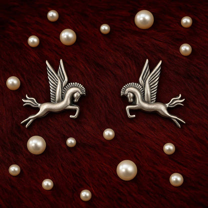 Pegasus earrings flatlay with pearl decorative styling