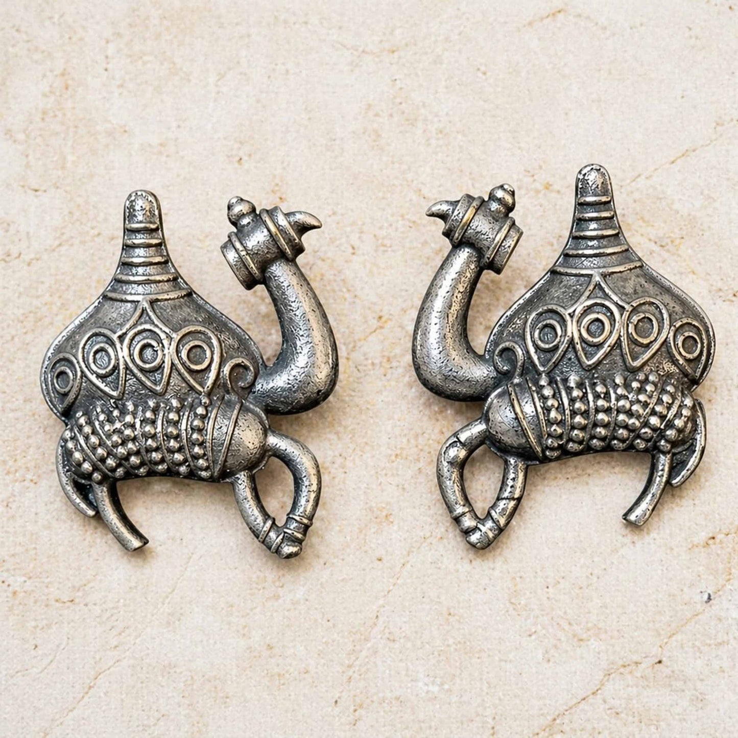 Detailed closeup of handcrafted camel motif silver earrings
