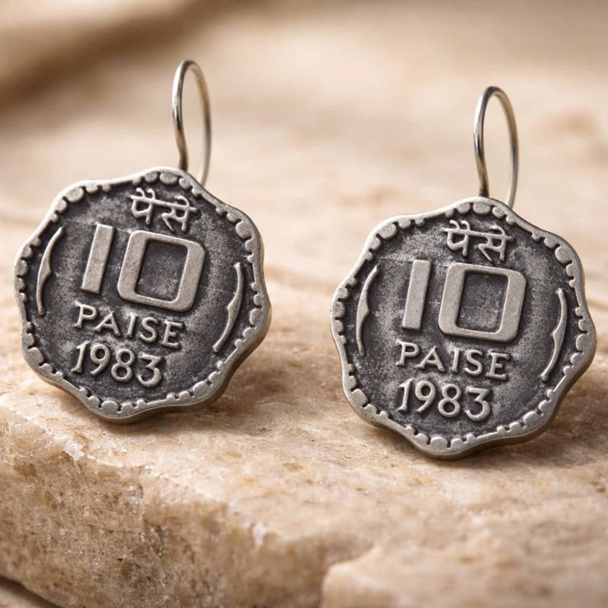 Antique style 10 paise earrings on textured background