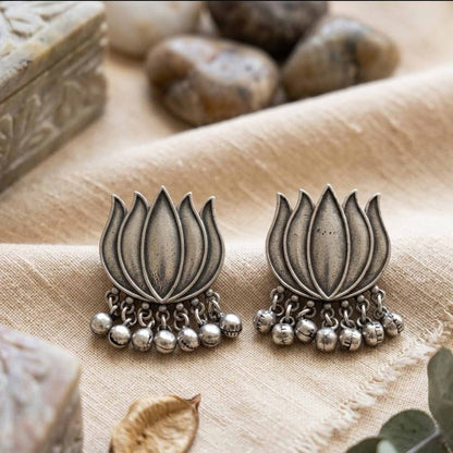 Traditional lotus ghunghru earrings on fabric styling background