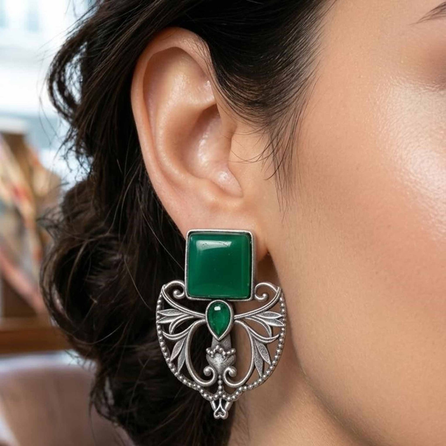 Closeup styling of emerald Art Nouveau earrings