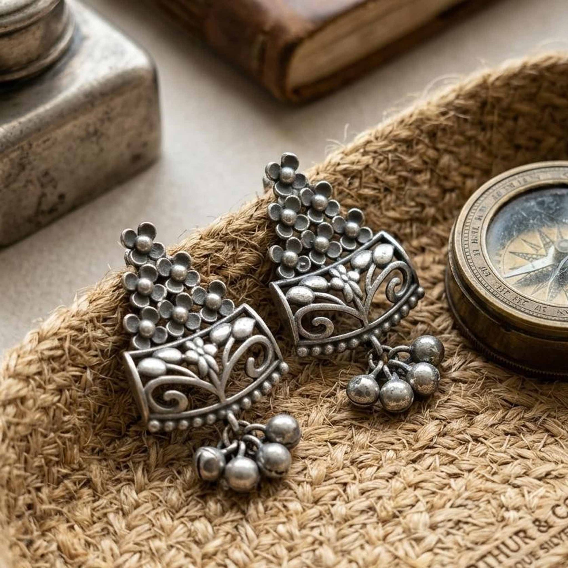 German silver floral earrings on woven mat with vintage styling