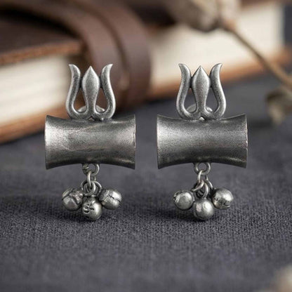 Traditional German Silver trishul earrings on dark backdrop