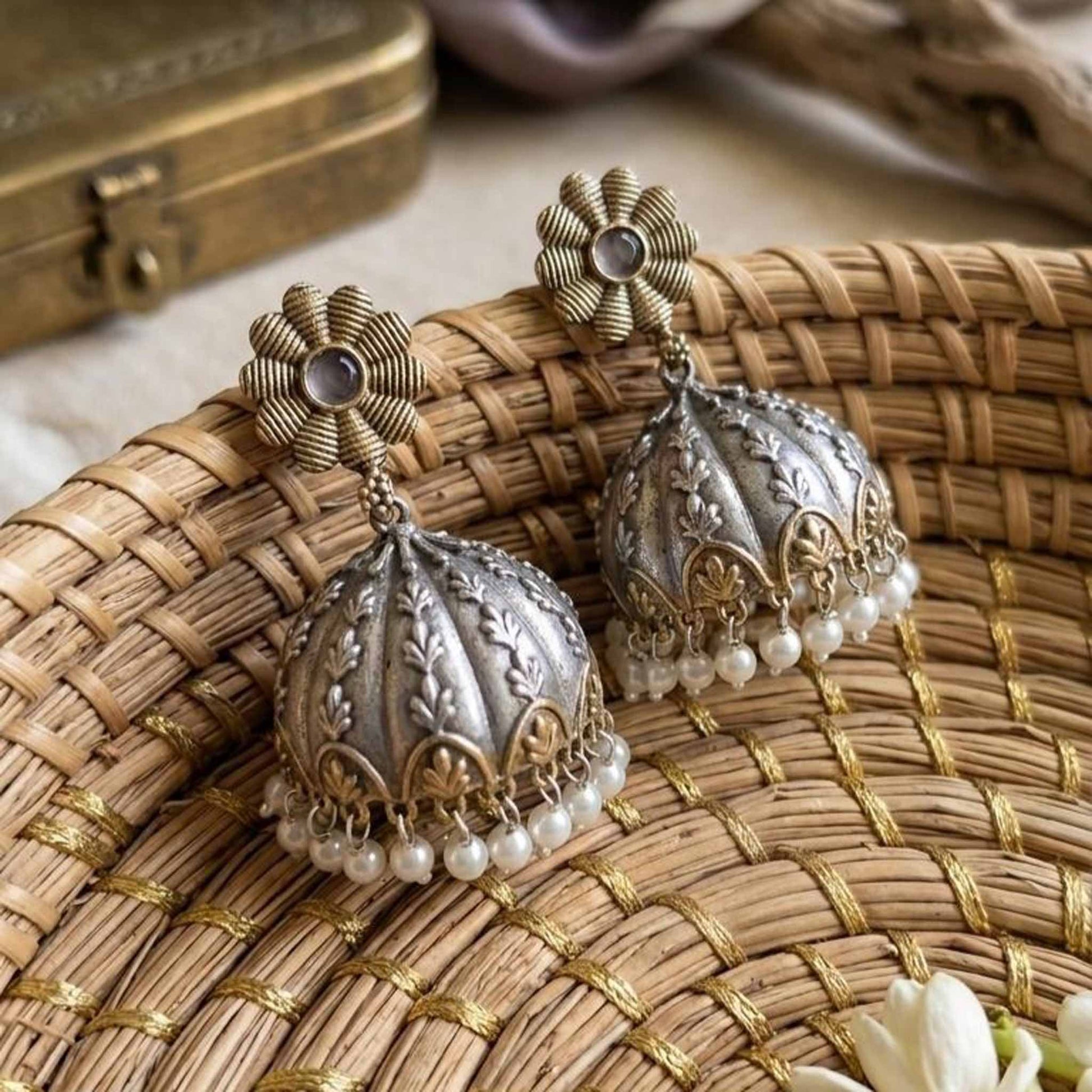 Pearl jhumka earrings on woven basket