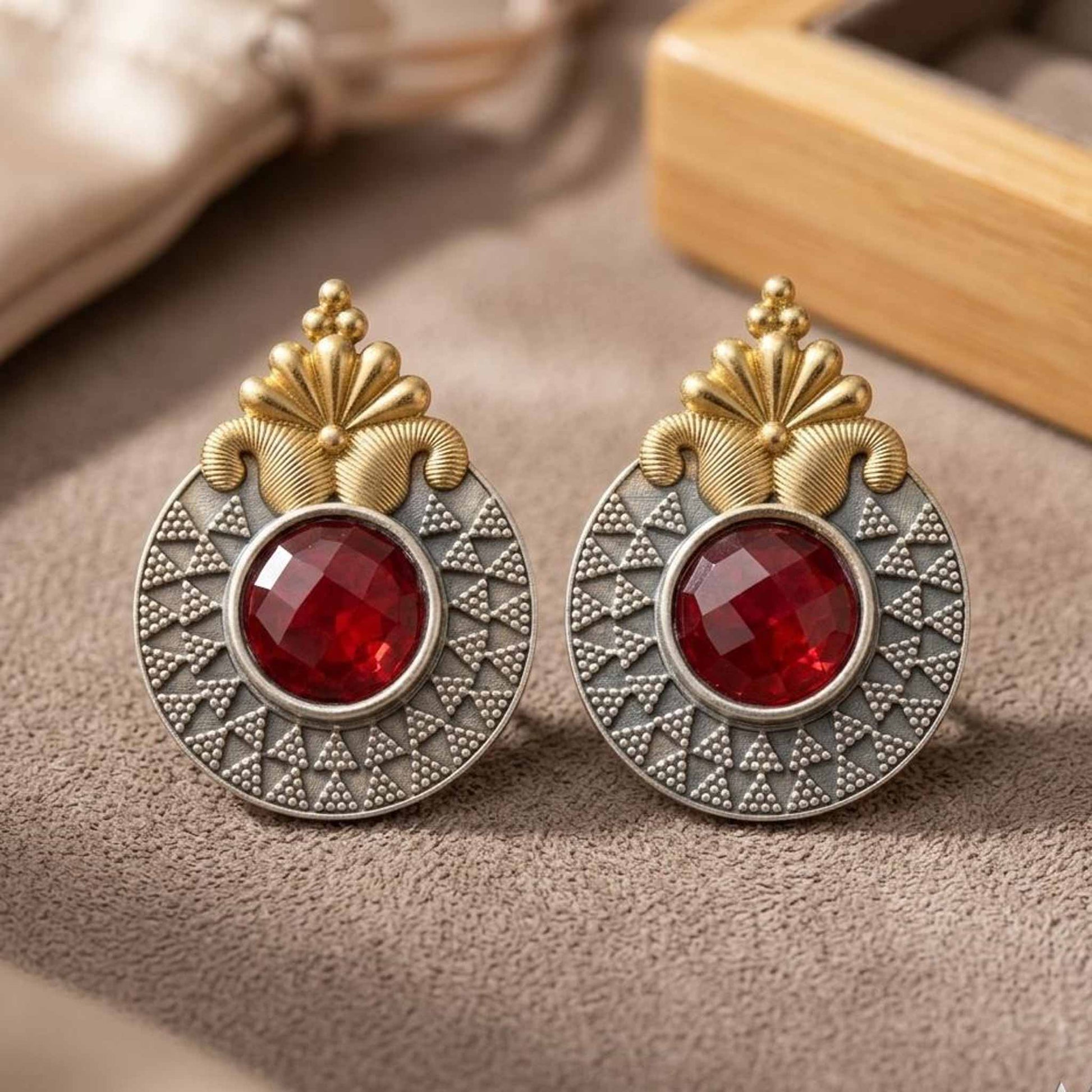 Dual tone ruby earrings product display on fabric