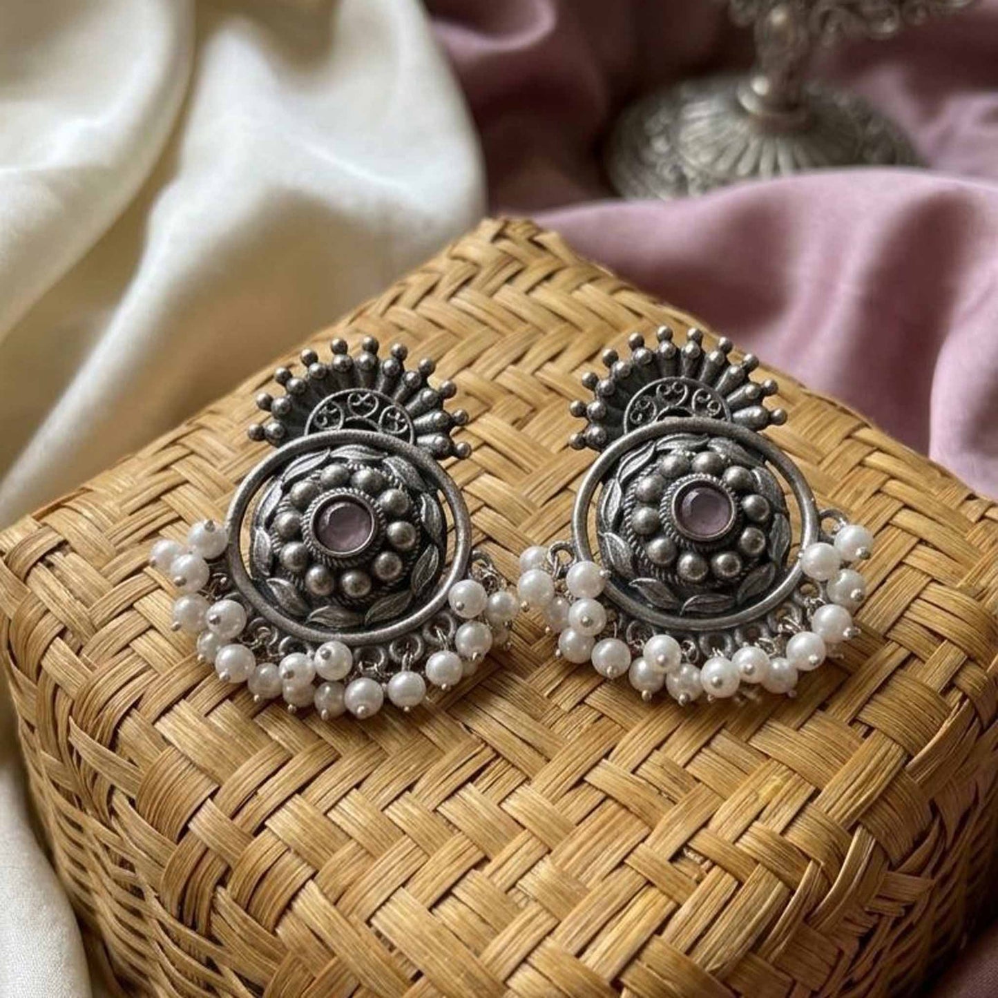 Traditional pearl chandbali earrings on woven basket