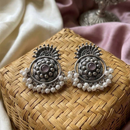 Traditional pearl chandbali earrings on woven basket