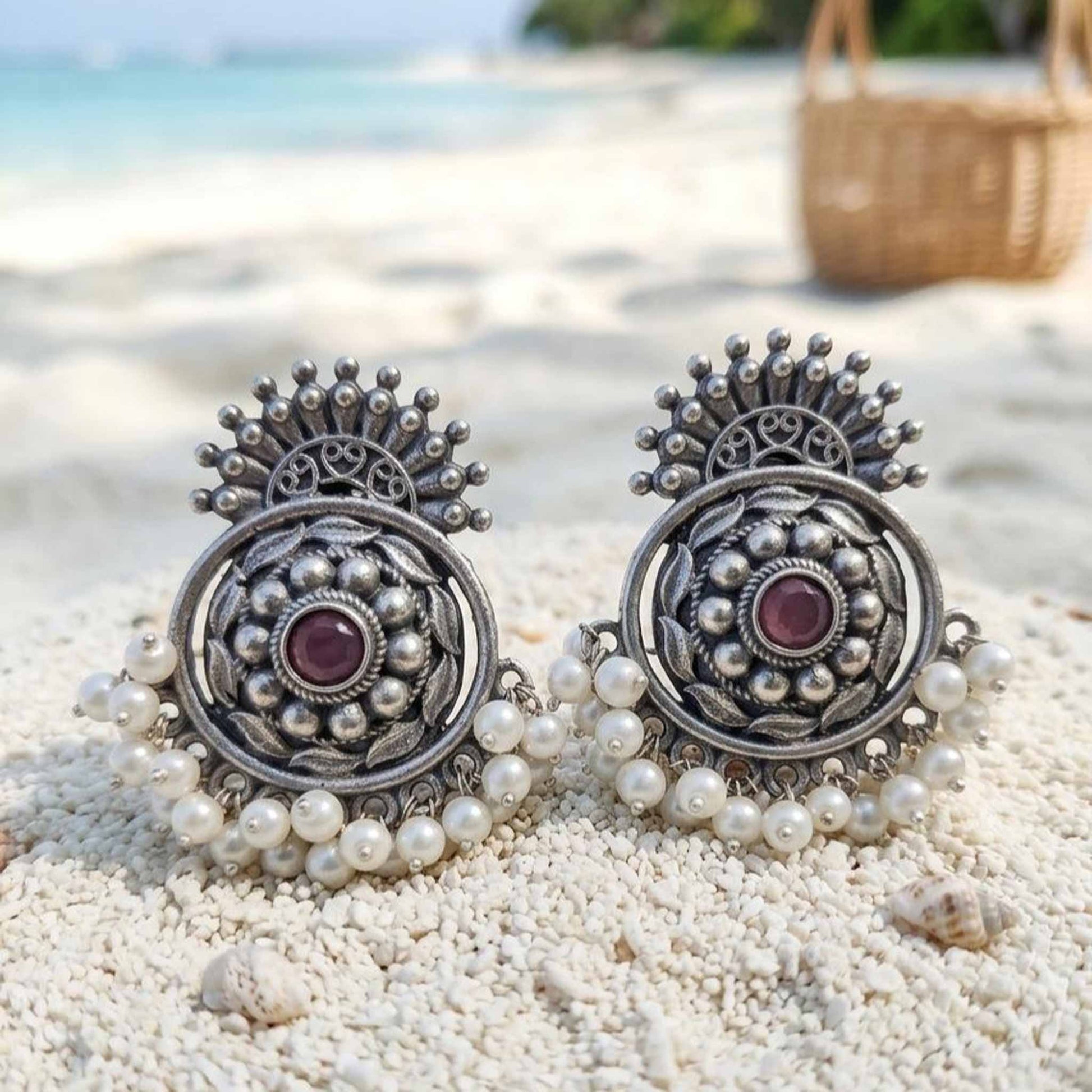 Pearl German Silver chandbali earrings displayed on beach sand