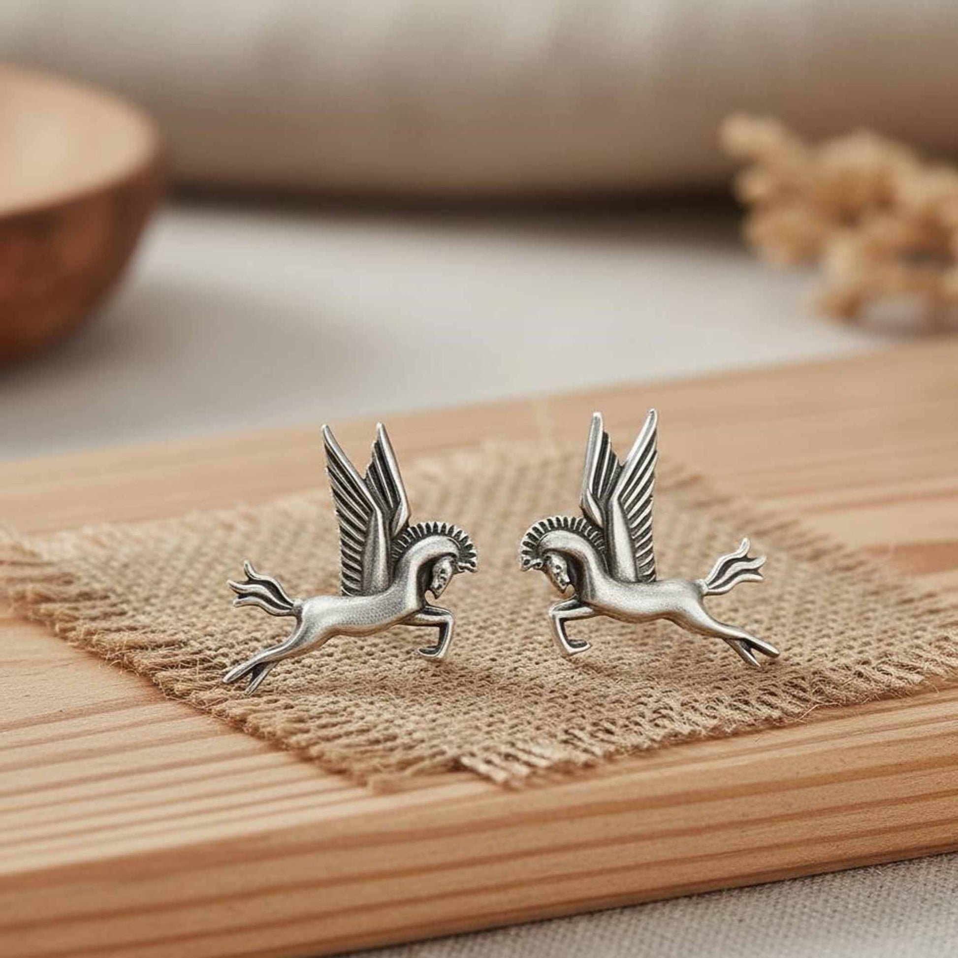 Pegasus winged horse German silver earrings display on wooden surface