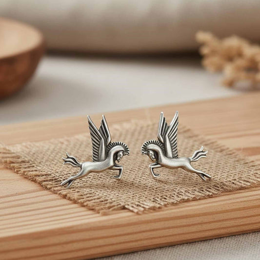 Pegasus winged horse German silver earrings display on wooden surface