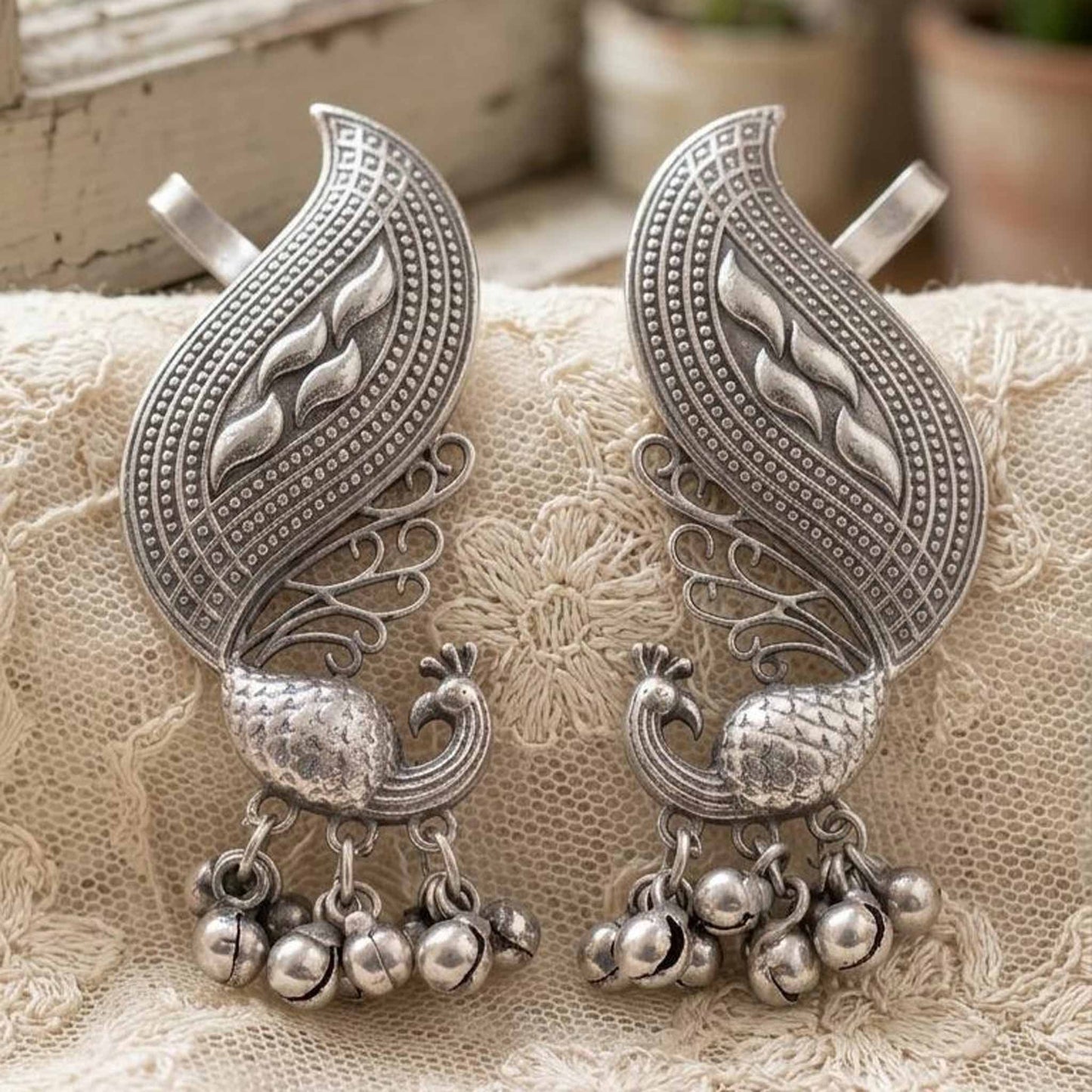 Traditional German Silver peacock earrings on lace fabric