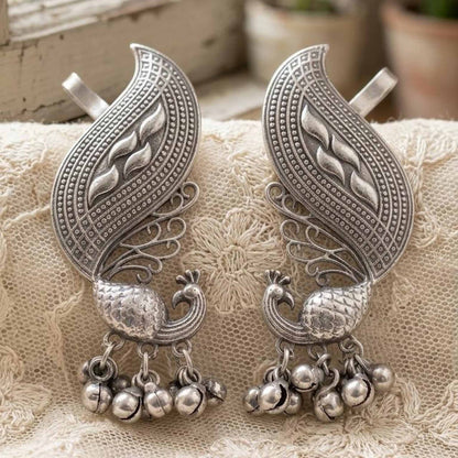 Traditional German Silver peacock earrings on lace fabric