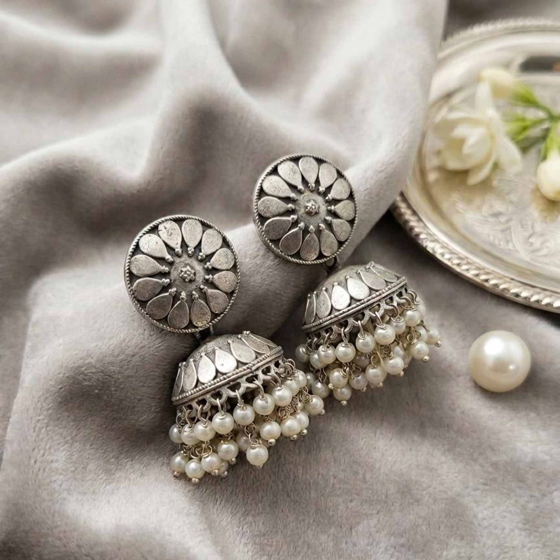 Elegant floral pearl jhumka earrings flatlay