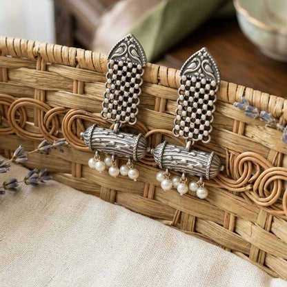 Heritage pearl dangler earrings displayed in woven basket