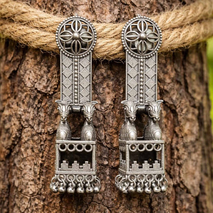 Traditional horse jharokha earrings displayed on tree bark