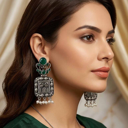 Woman wearing emerald green German silver pearl drop earrings